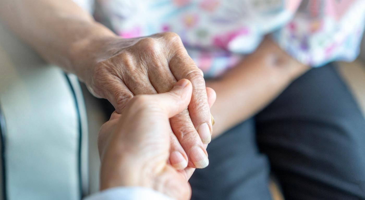 Two hands held together in a moment of quiet reassurance.